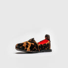 Leopard print slip-on shoe with red interior on a light gray background
