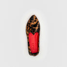 Leopard print flat shoe with red insole on a light gray background