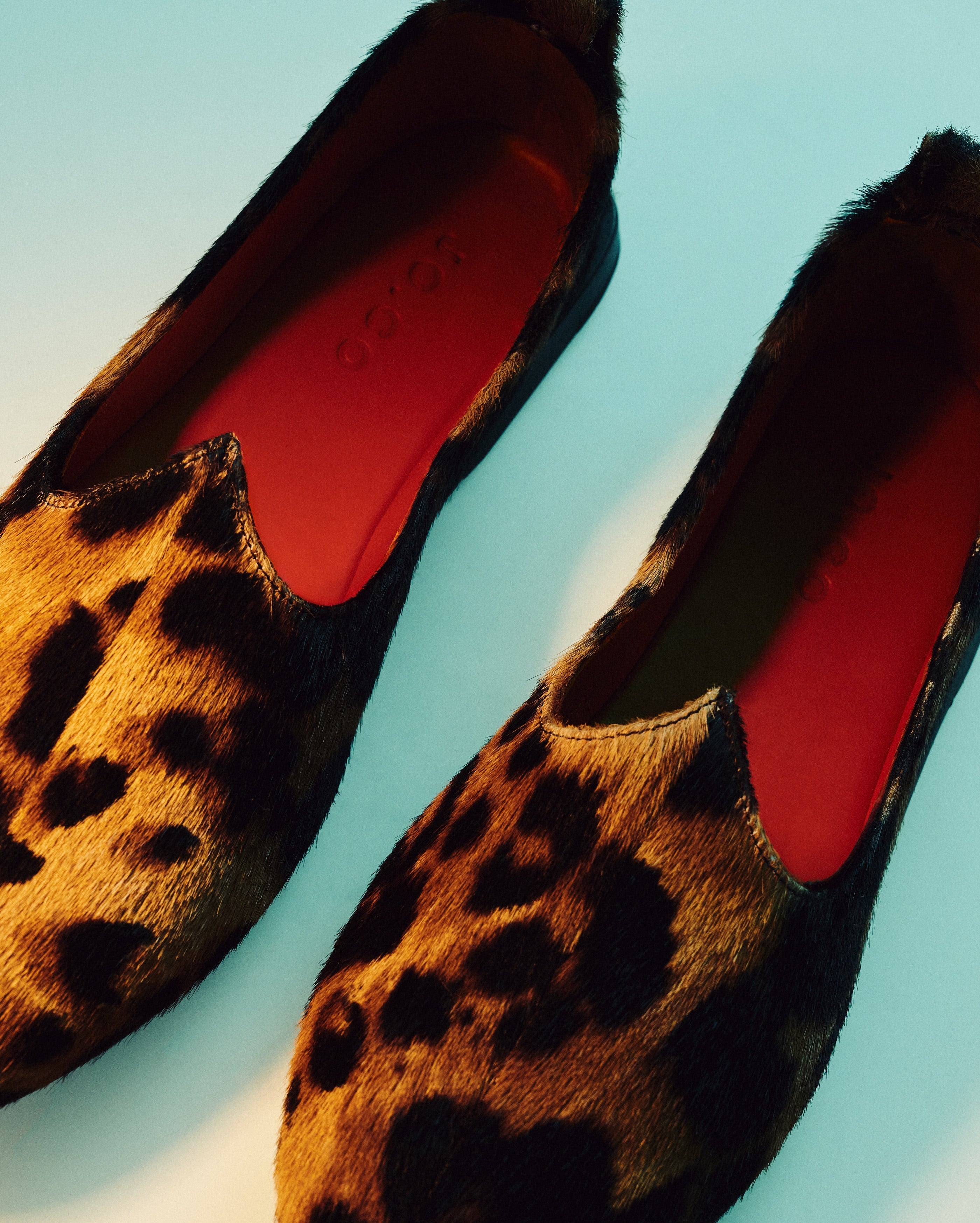 Pair of JOCO leopard hair-on Mojri loafers with red lambskin lining and JOCO-embossed insole